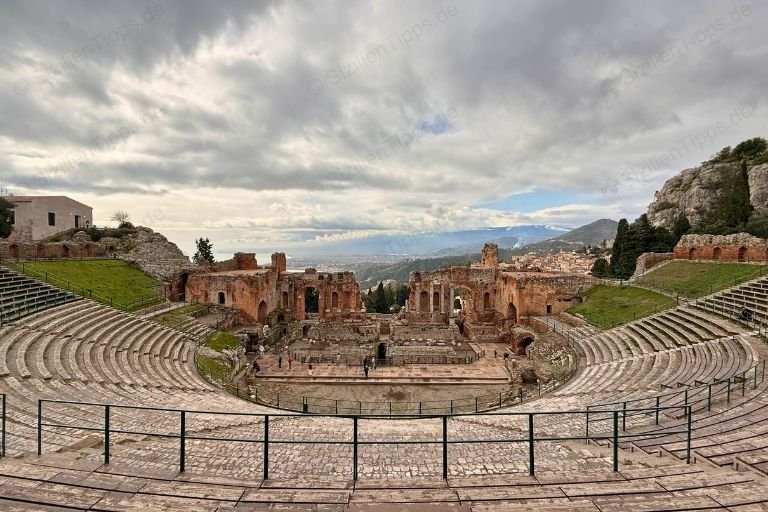 Sitzreihen und Ruinen in einem Theater über dem Meer