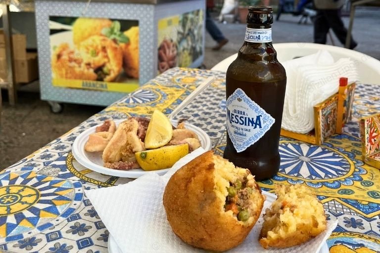 Frittierte Meeresfrüchte und ein gefülltes Reisbällchen mit einer Flasche sizilianischem Bier