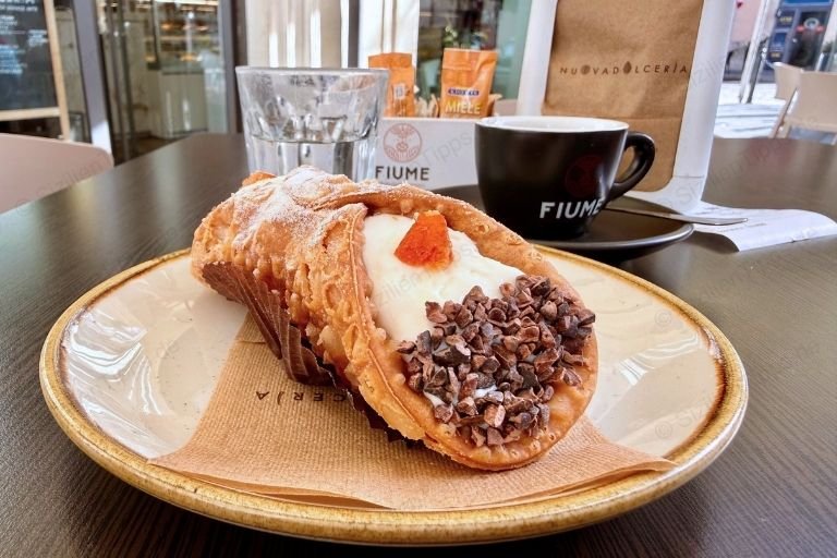 Ein Teigröllchen gefüllt mir Ricotta-Creme und Schokoladenstreuseln