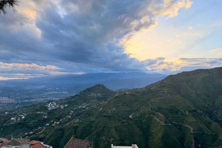 Grüne Hügel und dahinter der Ätna bei Sonnenuntergang