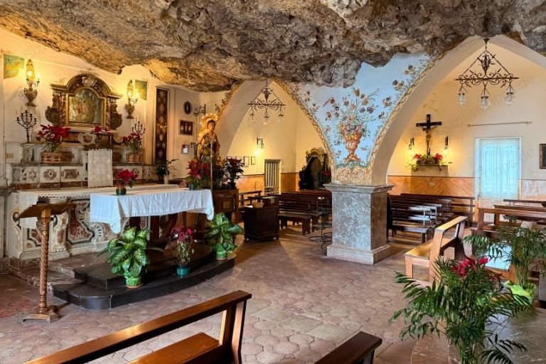 Bänke, Säulen und ein Altar in einer kleinen Kapelle