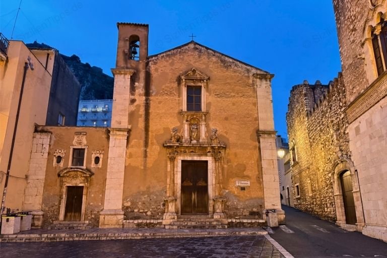 Eine beleuchtete Kirche mit kleinem Glockenturm in Taormina