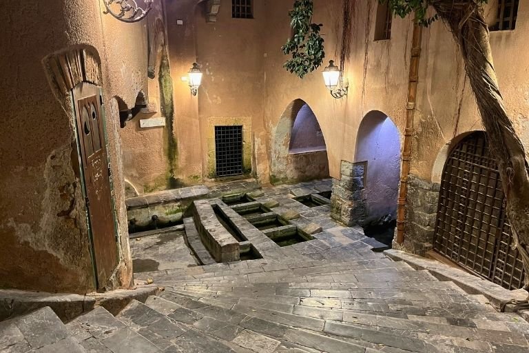 Treppen führen zu einem alten Waschplatz in Cefalù