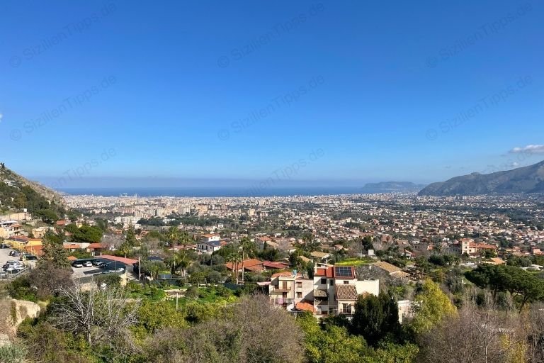Ausblick von Monreale auf Häuser, Bäume und das Meer in Palermo