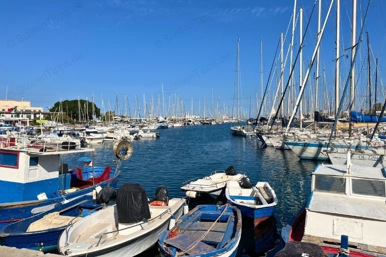 Boote unter blauem Himmel in Palermos Hafenbucht La Cala