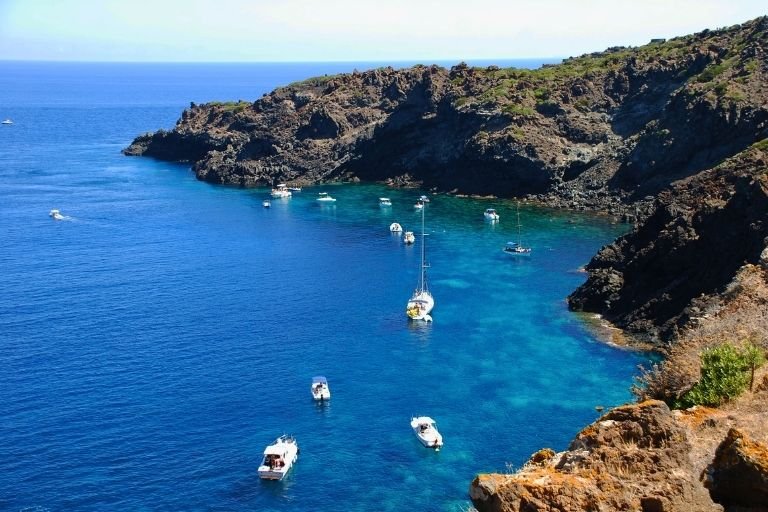 Weiße Boote in den felsigen Buchten der sizilianischen Insel Pantelleria