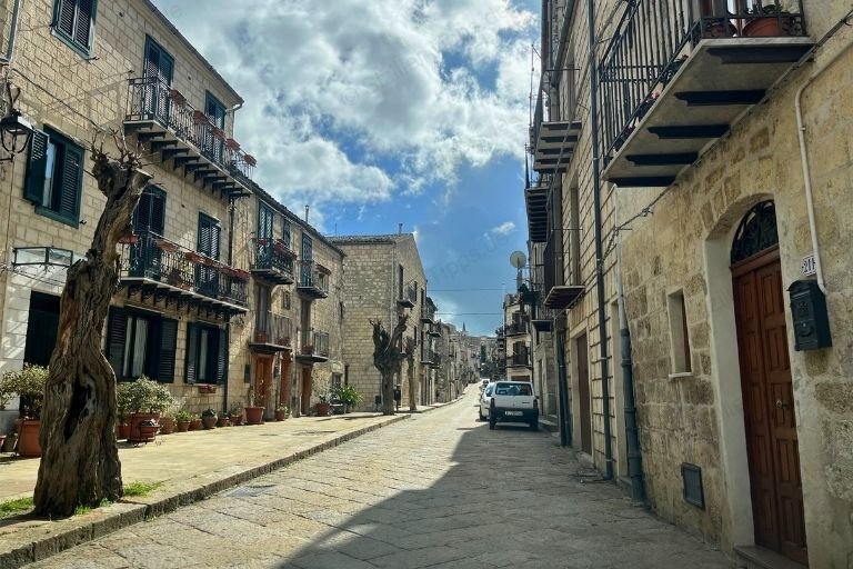 Eine Straße mit sandstein-farbenen Häusern in Petralia Soprana