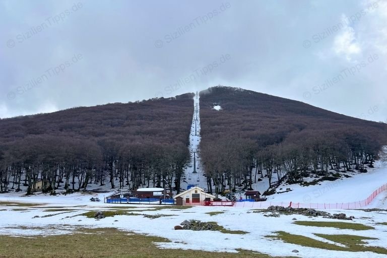 Ein Skigebiet mit einem Lift inmitten von Bäumen im Parco delle Madonie