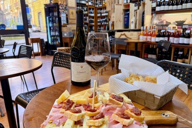 Vorspeisenplatte und Rotwein in einer Weinbar in Randazzo auf Sizilien.