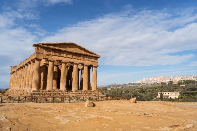 Ein gut erhaltener antiker Tempel und die Stadt Agrigent im Hintergrund