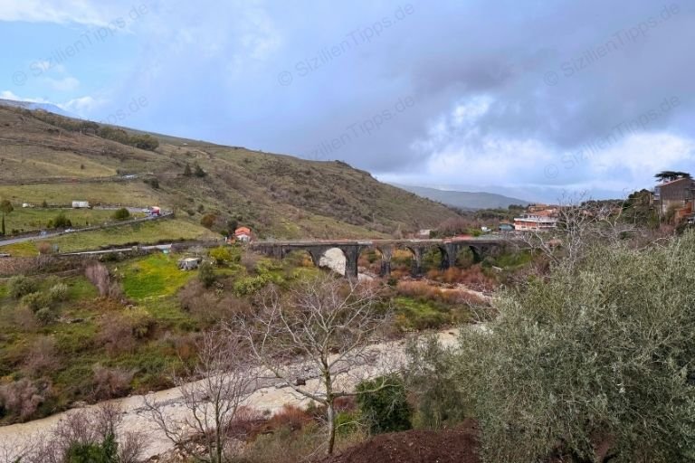 Ein Fluss, der von einer Steinbrücke überspannt wird.