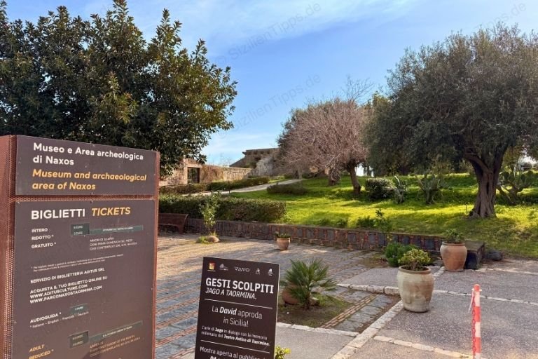 Schilder, Büsche und Bäume vor antiken Mauern