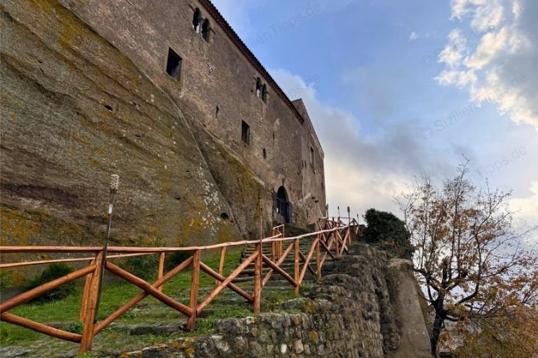 Weg mit Geländer hinauf zu einer Burg