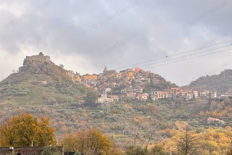 Ein Dorf auf einem Hügel unter grauem Himmel