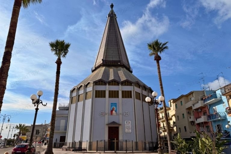Palmen um eine Kirche unter blauem Himmel