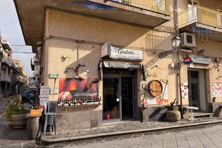 Weinflaschen vor einem gelben Gebäude in Randazzo